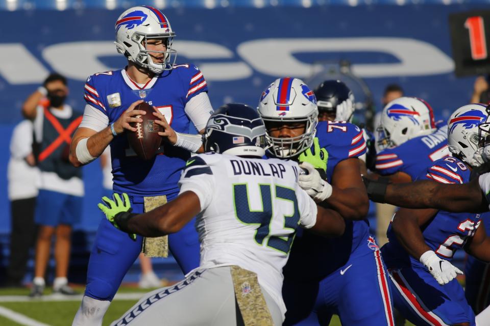 Buffalo Bills quarterback Josh Allen, left, looks to pass as teammate offensive tackle Daryl Williams (75) blocks Seattle Seahawks Carlos Dunlap (43) during the first half of an NFL football game Sunday, Nov. 8, 2020, in Orchard Park, N.Y. (AP Photo/Jeffrey T. Barnes)