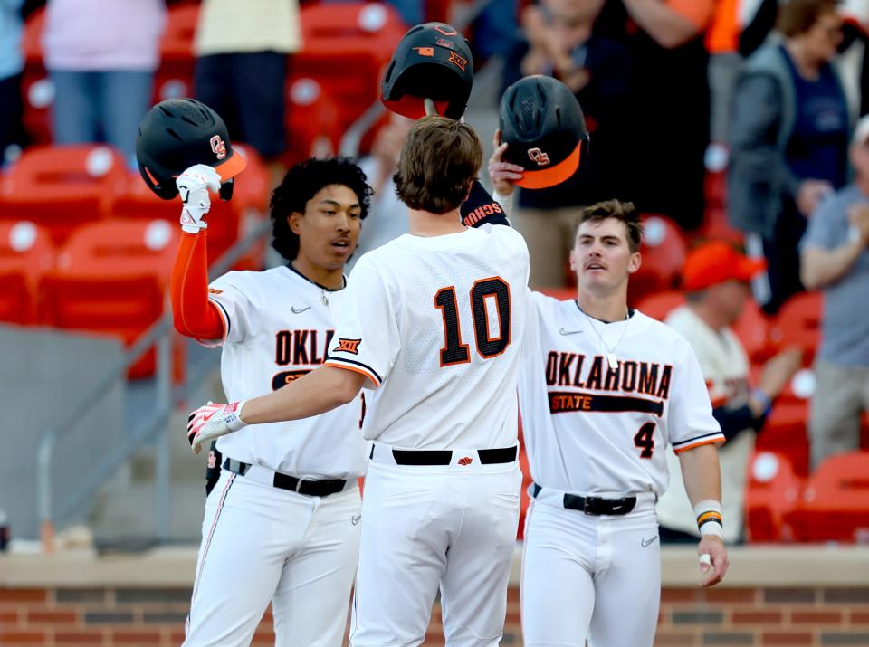 OSU's Nolan Schubart (10) celebrates a home run with Donovan LaSalle (19) and Zach Ehrhard (4) in the first inning Friday night in a 9-6 win against OU at O'Brate Stadium in Stillwater.