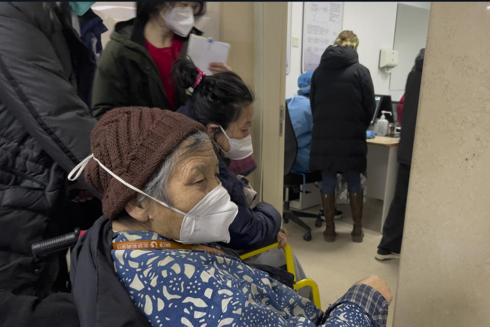 An elderly patient wearing a face mask looks as patients wait to see a doctor at the emergency ward of a hospital in Beijing, Thursday, Jan. 5, 2023. Patients, most of them elderly, are lying on stretchers in hallways and taking oxygen while sitting in wheelchairs as COVID-19 surges in China's capital Beijing. (AP Photo/Andy Wong)