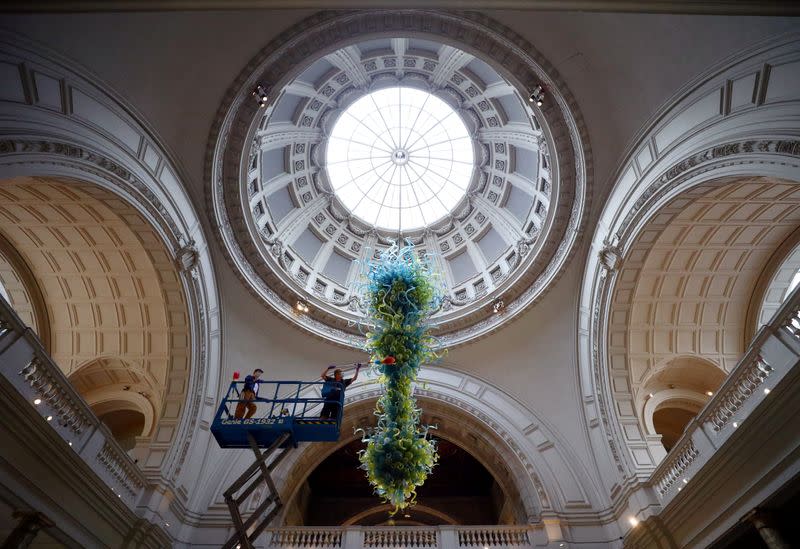 A museum technician cleans the V&A Rotunda Chandelier by Dale Chihuly during preparations to reopen the Victoria & Albert (V&A) Museum, in London