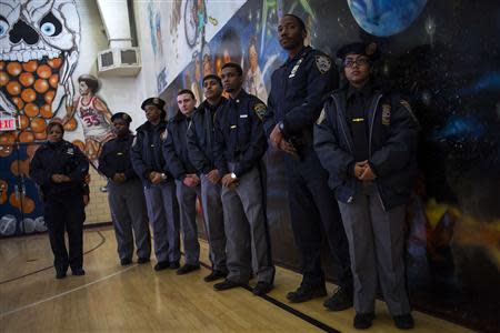 New York Police Department officers and explorers listen as Mayor Bill de Blasio speaks at a news conference in the Brownsville neighborhood in the borough of Brooklyn, New York January 30, 2014. REUTERS/Eric Thayer