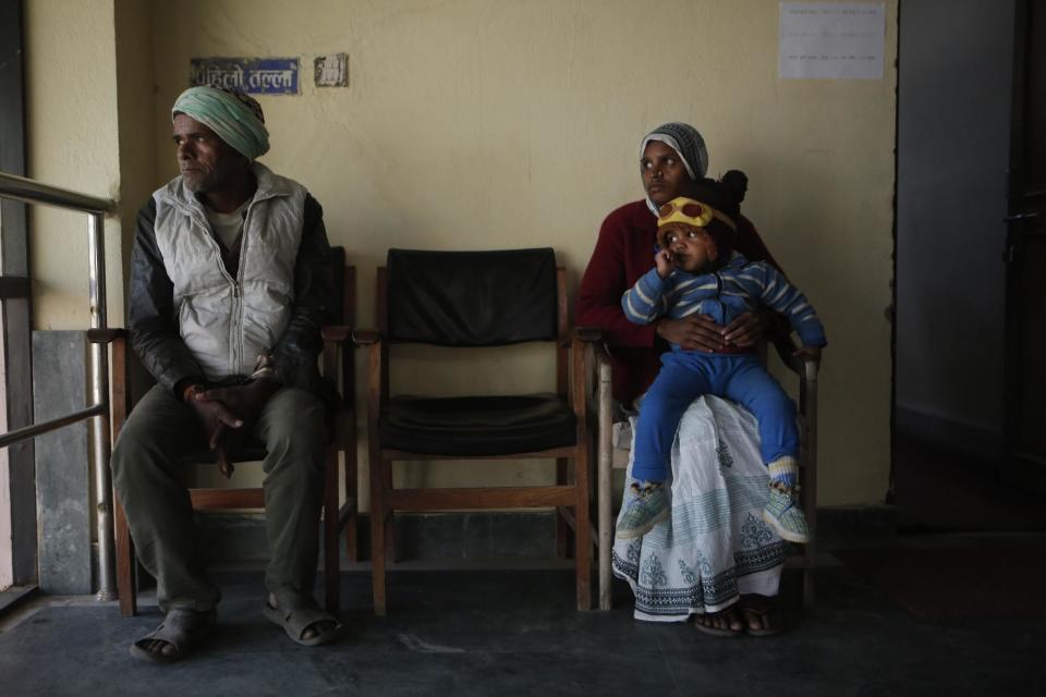 In this photo taken on Monday, Dec 19, 2016, Saro Kumari Mandal, 26, sits with her son and her father-in-law at the Department of Foreign Employment to receive compensation after her husband died as a migrant worker in Qatar, in Kathmandu, Nepal. Eventually, with help, she received $2,777 from the Foreign Employment Promotion Board. She said she would use the money to open a small store in the village selling cookies and noodles, and also invest in a sewing machine. She wants to earn money for their son's education. "I want to make my son a teacher or a doctor when he grows up," she said. (AP Photo/Niranjan Shrestha)