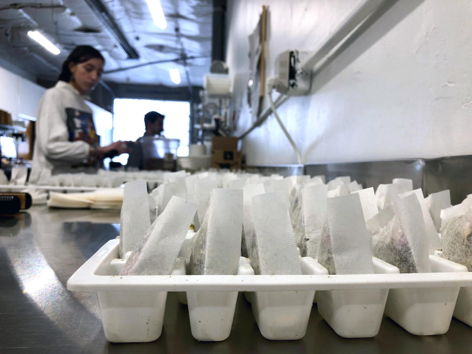 In this Dec. 17, 2019, photo, Sarah Sall, an employee of The Brothers Apothecary, makes teabags filled with hemp and other botanicals at the company warehouse in Portland, Ore. The co-owner of the tea company is concerned that interim hemp farming rules put out by the U.S. Department of Agriculture will destroy his supply chain of hemp and hurt the rapidly growing hemp industry. (AP Photo/Gillian Flaccus)