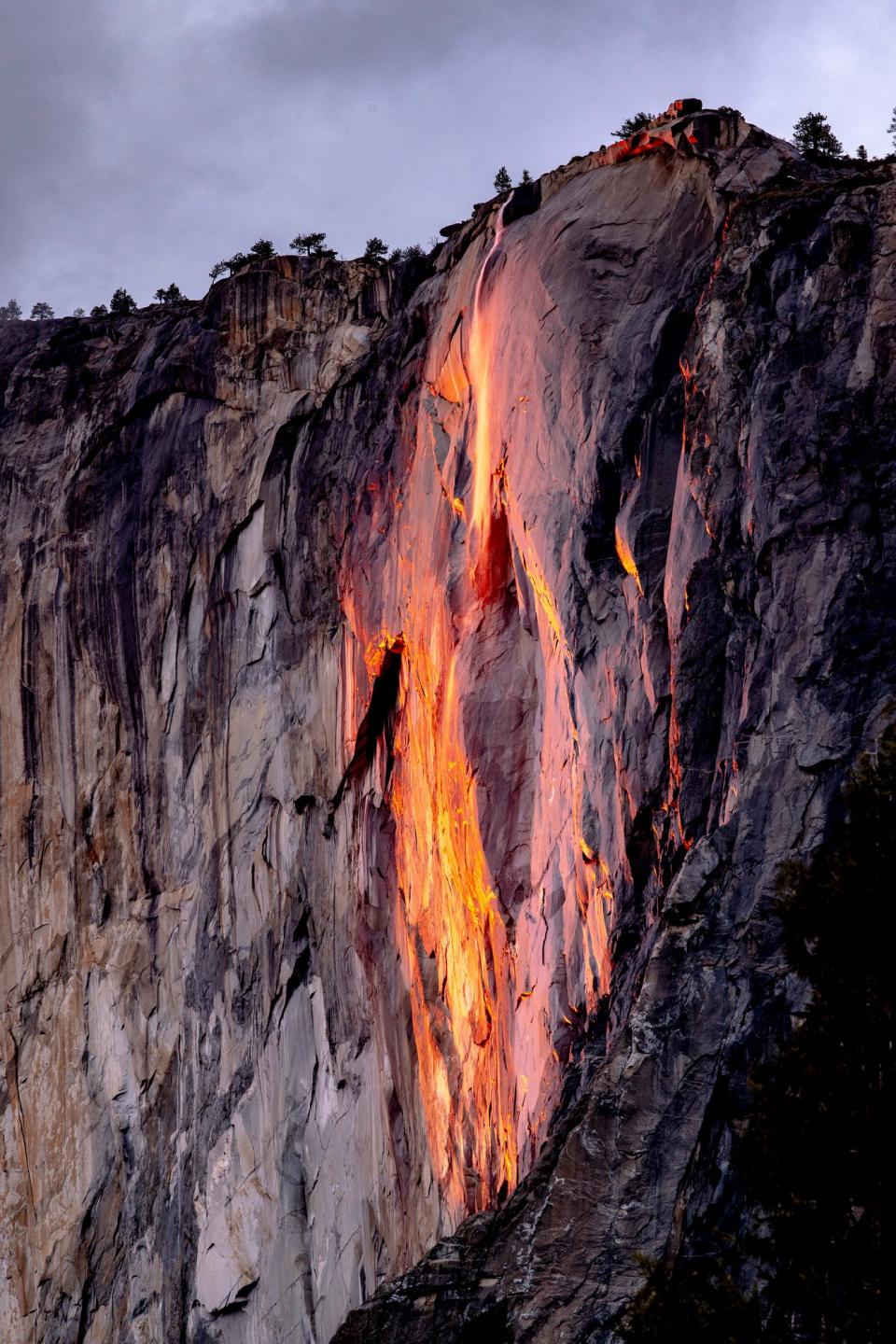 A narrow slit of light from the setting sun illuminates Horsetail Fall in Yosemite National Park on Tuesday, February 16, 2021.