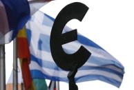 A Greek flag flies behind a statue to European unity outside the EU Parliament in Brussels, Belgium, May 20, 2015. REUTERS/Francois Lenoir