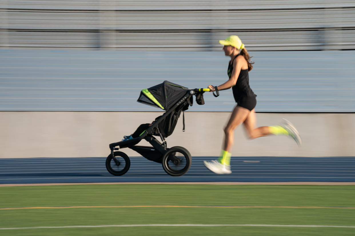 Neely Gracey, wearing fluorescent green socks and baseball cap, and a stroller with a fluorescent green streak on the hood, runs along a track.