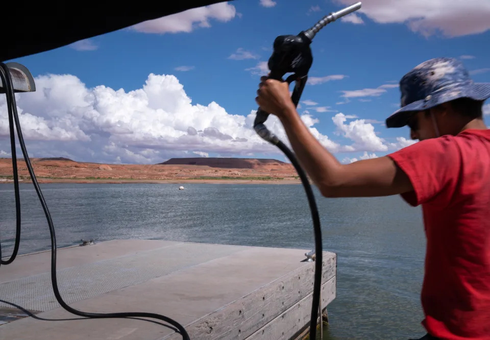 A Bullfrog Marina employee fuels a watercraft at Lake Powell on Aug. 16, 2022. The marina was scheduled to be moved into the Colorado River main channel because of declining water levels.