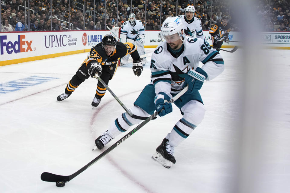 San Jose Sharks' Erik Karlsson clears the puck before Pittsburgh Penguins' Sidney Crosby can get to it during the second period of an NHL hockey game in Pittsburgh, Saturday, Jan. 28, 2023. (AP Photo/Gene J. Puskar)