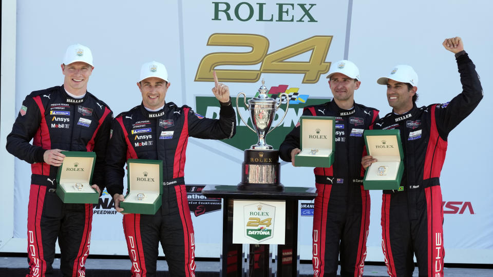 Porsche Penske Motorsport team drivers, from left, Josef Newgarden, Dane Cameron, Matt Campbell, of Australia, and Felipe Nasr, of Brazil celebrate with new Rolex watches in Victory Lane after winning the Rolex 24 hour auto race at Daytona International Speedway, Sunday, Jan. 28, 2024, in Daytona Beach, Fla. (AP Photo/John Raoux)