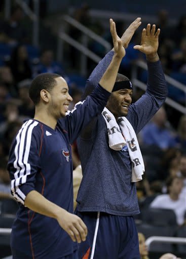 Atlanta Hawks' Devin Harris, left, and Josh Smith come off the bench during a time out to celebrate during the final minutes of an NBA basketball game against the Orlando Magic, Wednesday, Feb. 13, 2013, in Orlando, Fla. Atlanta won 108-76.(AP Photo/John Raoux)