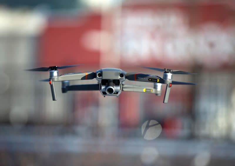 FILE PHOTO: A drone flies as Chinese drone maker DJI demonstrates their app that tracks a drone's registration and owner in Montreal