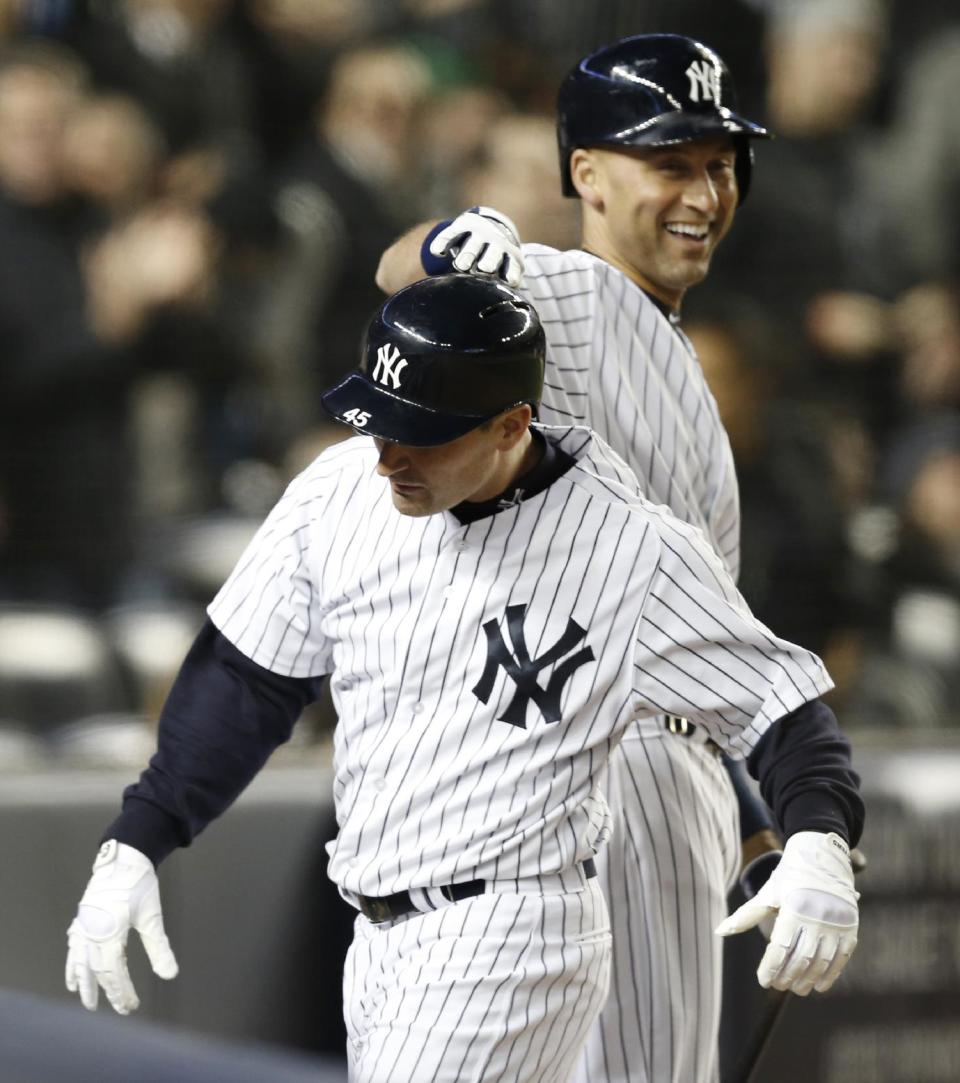 New York Yankees on-deck batter Derek Jeter, top, pats teammate Dean Anna on the helmet after Anna hit a fifth-inning solo home run off Boston Red Sox starting pitcher Clay Buchholz in a baseball game at Yankee Stadium in New York, Thursday, April 10, 2014. (AP Photo/Kathy Willens)