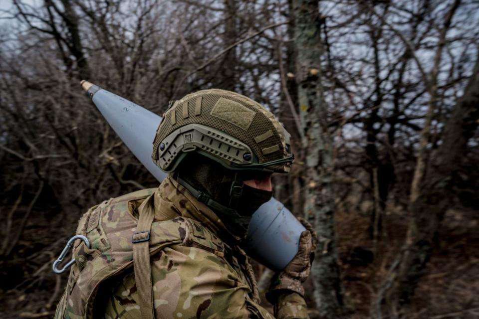 A Ukrainian serviceman carries a Soviet-style 152 mm shell to fire a Msta-B howitzer towards Russian positions near the frontline town of Bakhmut on March 2, 2023, amid the Russian invasion of Ukraine. (Photo by Dimitar Dilkoff/Getty Images)
