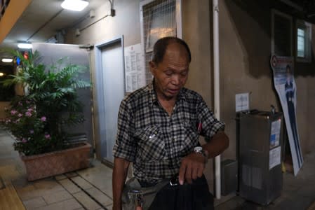 Lou Tit-Man, 73, looks at his watch at Mong Kok in Hong Kong