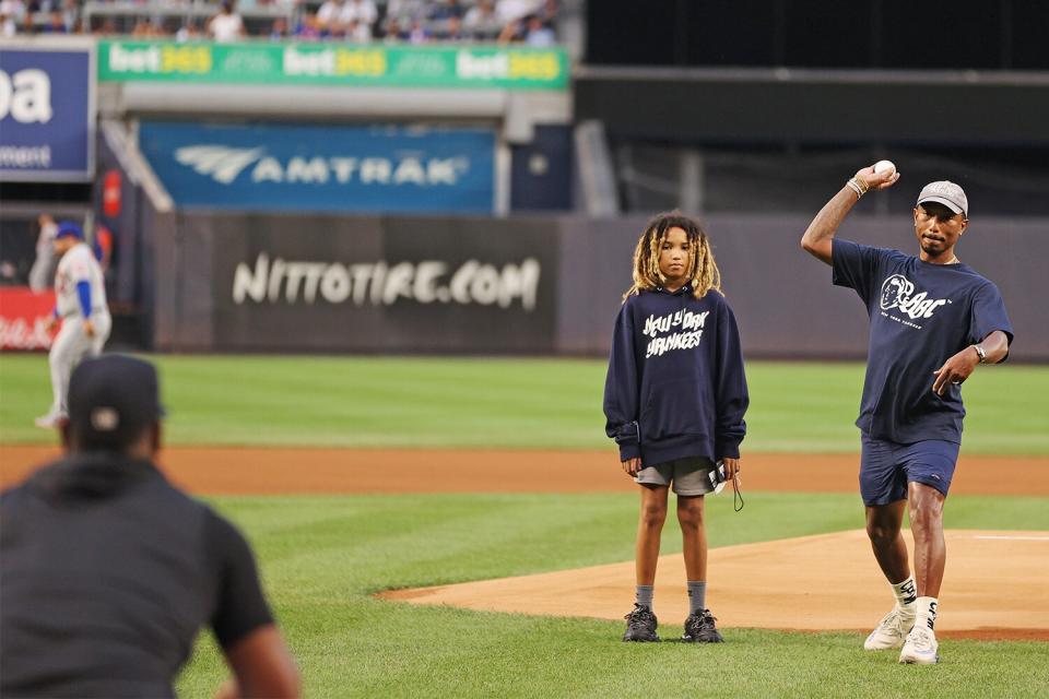 Musician Pharrell Williams throws a ceremonial first pitcher to Luis Severino of the New York Yankees before the first inning against the New York Mets at Yankee Stadium on August 22, 2022 in the Bronx borough of New York City.