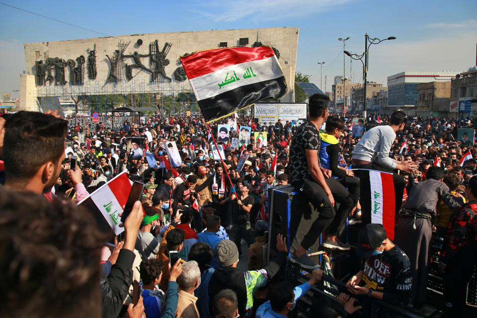 Followers of Shiite cleric Muqtada al-Sadr,gather in Tahrir Square, Baghdad, Iraq, Friday, Nov. 27, 2020. Thousands took to the streets in Baghdad on Friday in a show of support for a radical Iraqi cleric ahead of elections slated for next year, stirring fears of a spike in coronavirus cases. (AP Photo/Khalid Mohammed)