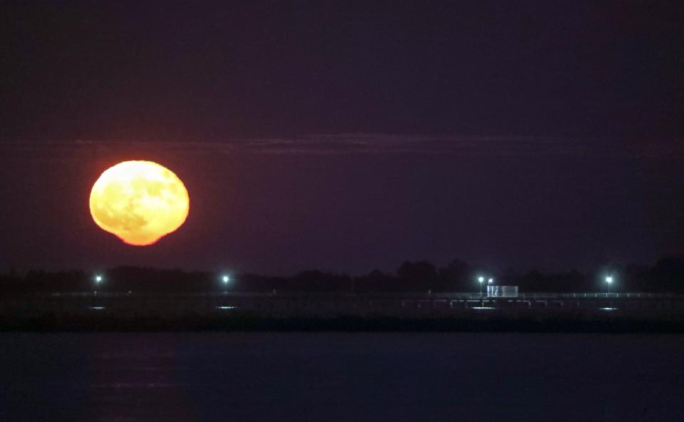 The moon rises over the Delaware Bay during a Full Moon Gathering led by Mandie Stevenson at dusk on the beach in Lewes, Thursday, Oct. 21, 2021.