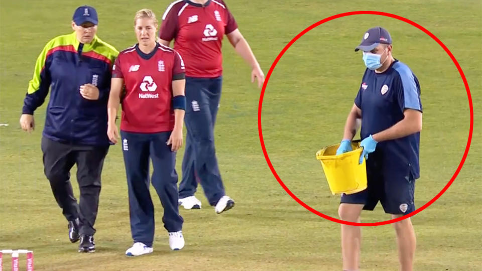 A groundsman can be seen here bringing sawdust out to place on the pitch.