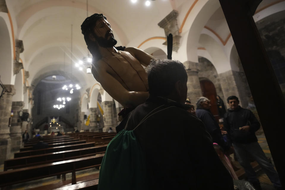 A man carries the image of Jesus Christ previous the procession for the Holy Week in Puellaro, Ecuador, Wednesday, April 5, 2023. (AP Photo/Dolores Ochoa)