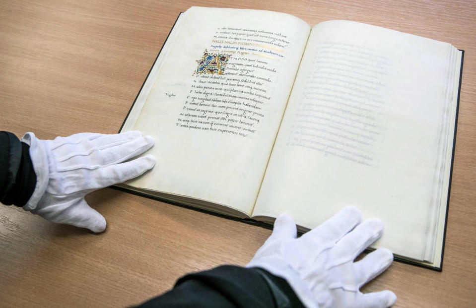 A librarian displays a unique 15th century ornamented manuscript on parchment in a library in Torun, Poland, on Monday, Feb. 14, 2022. Local authorities and officials in central Poland are protesting government plans to offer Hungary a unique 15th century ornamented manuscript that is the most precious item of a library in Torun. A lawmaker with Poland's right-wing ruling party has proposed legislation that would allow the government to take possession of the manuscript and offer it to the government of Prime Minister Viktor Orban. (AP Photo/Andrzej Goinski)