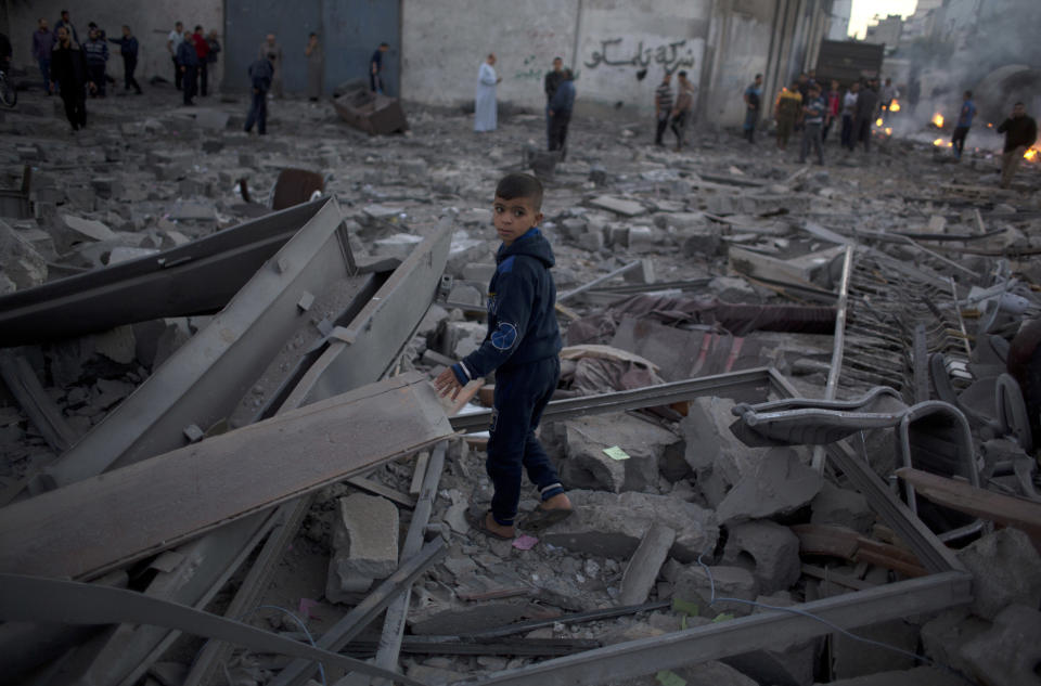 A Palestinian boy stands in the middle of the rubble of buildings destroyed by Israeli airstrikes early morning in Gaza City, Saturday, Oct. 27, 2018. Israeli aircraft have struck dozens of militant sites across the Gaza Strip as militants fired some 30 rockets into Israel. (AP Photo/Khalil Hamra)