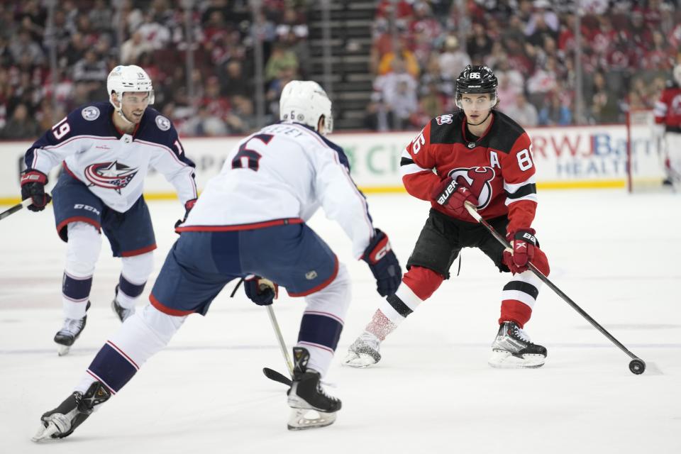 New Jersey Devils center Jack Hughes (86) skates against Columbus Blue Jackets defenseman Billy Sweezey (6) and center Liam Foudy (19) during the second period of an NHL hockey game Thursday, April 6, 2023, in Newark, N.J. (AP Photo/Mary Altaffer)