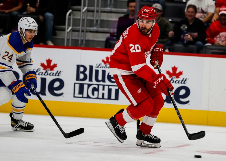Detroit Red Wings right wing Luke Witkowski (20) protects the puck against Buffalo Sabres center Dylan Cozens (24) during the second period of a preseason game at Little Caesars Arena in Detroit on Thursday, Sept. 30, 2021.