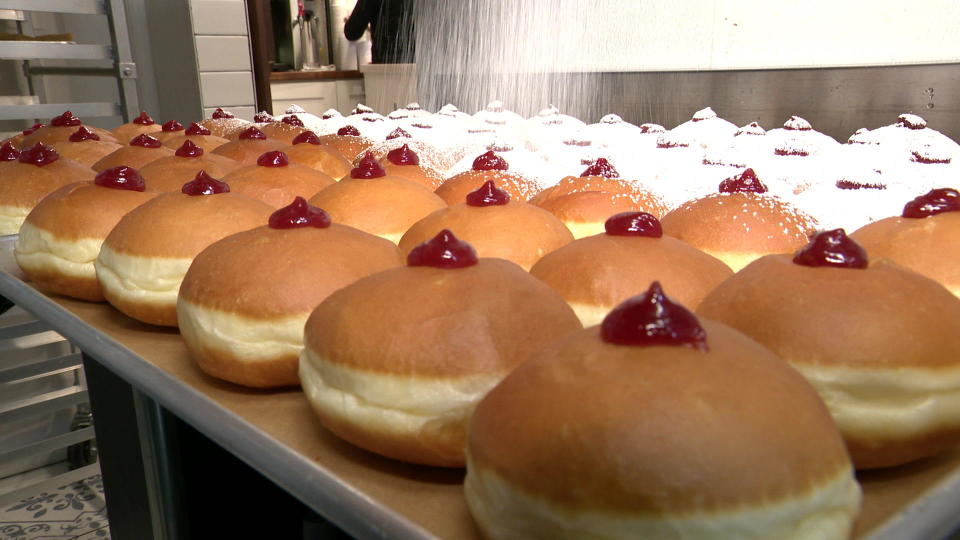 Preparing jelly doughnuts (or sufganiyot) for Hanukkah.  / Credit: CBS News