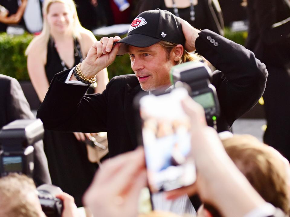 Actor Brad Pitt puts on a Kansas City Chiefs hat at the 26th annual Screen Actors Guild Awards at The Shrine Auditorium on Jan. 19, 2020.