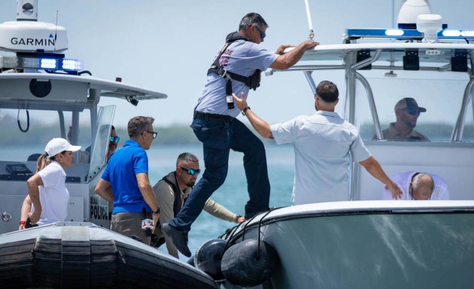 A Miami-Dade Fire-Rescue officer jumps on a separate police boat to assist a passed-out passenger on Wednesday, July 3, 2024, in Key Biscayne, Florida.