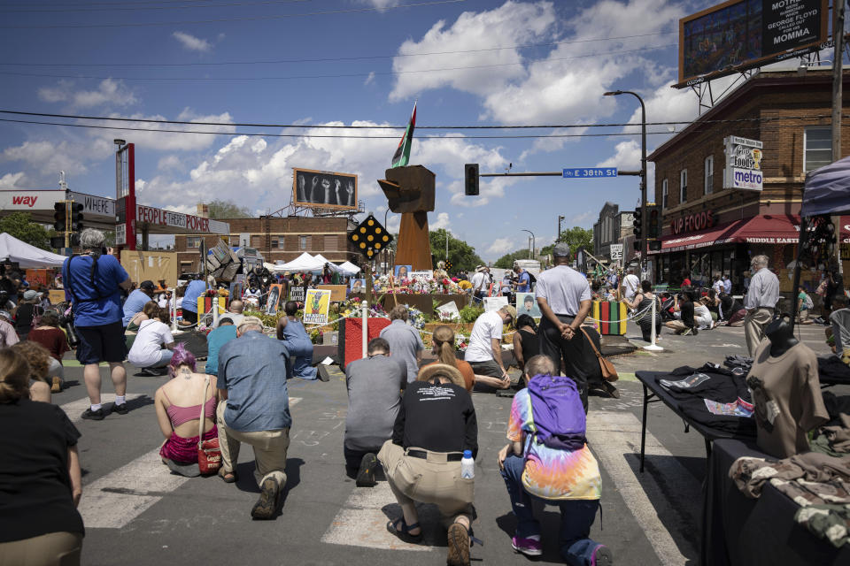 People take a knee during a moment of silence on the one year anniversary of George Floyd's death on Tuesday, May 25, 2021, in Minneapolis, Minn. (AP Photo/Christian Monterrosa)