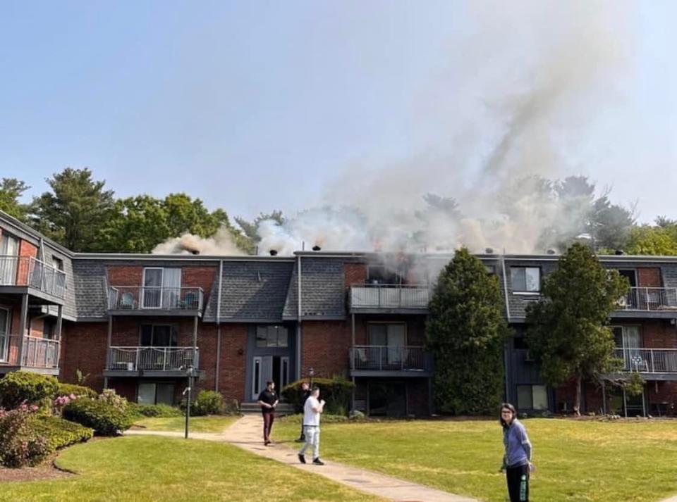 Smoke billows from an apartment building Wednesday morning on Stoneybrook Drive in Millis.