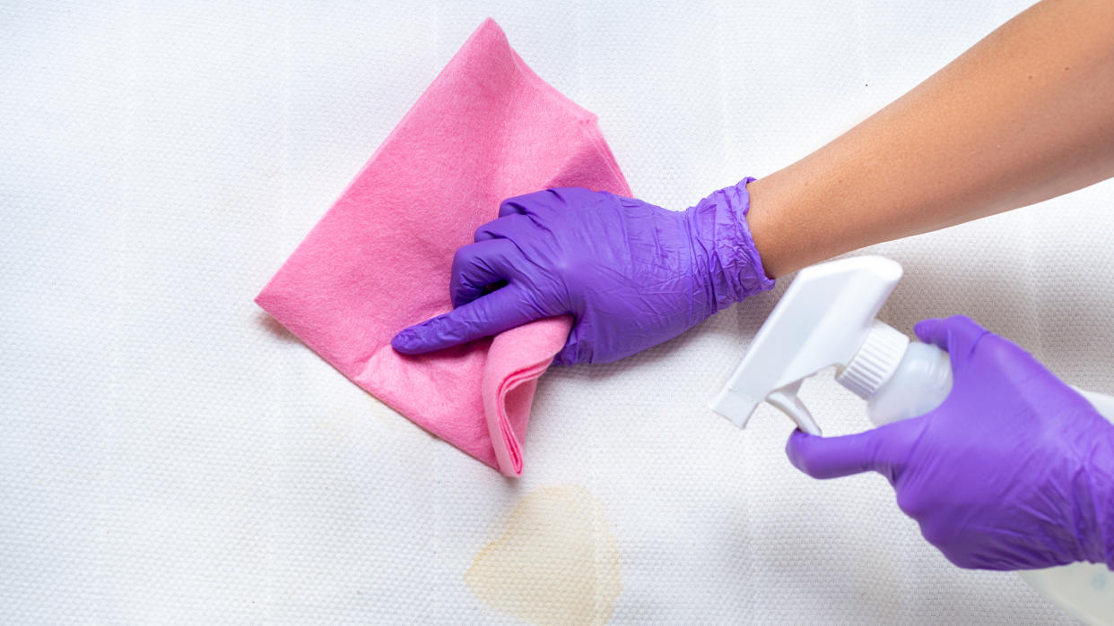  Woman cleaning a mattress topper. 