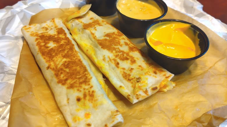 two burritos with cheese sauce