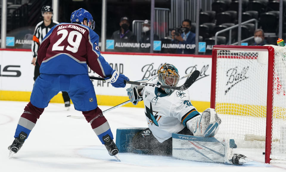 Colorado Avalanche center Nathan MacKinnon, left, scores a goal against San Jose Sharks goaltender Josef Korenar in the second period of an NHL hockey game Saturday, May 1, 2021, in Denver. (AP Photo/David Zalubowski)