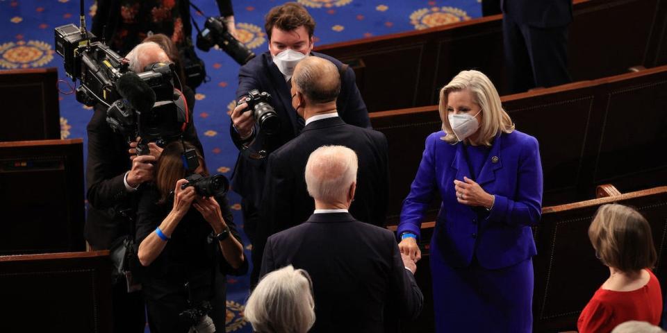 President Joe Biden (C) greets Rep. Liz Cheney (R-WY) with a fist bump before addressing a joint session of congress in the House chamber of the US Capitol April 28, 2021 in Washington, DC.