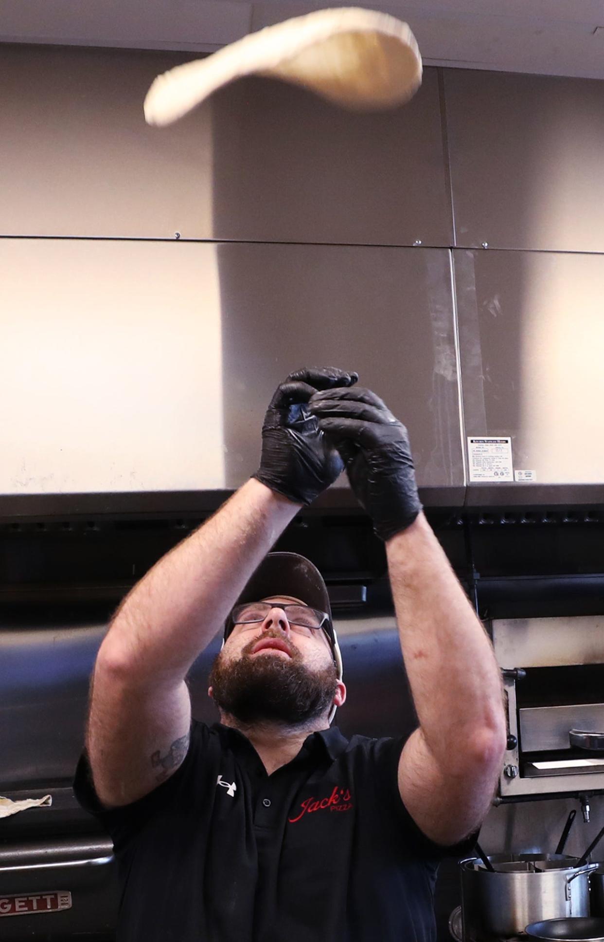 Cody Hornyak, owner of Jack's Pizza, hand tosses pizza dough in his in Brimfield Township eatery.