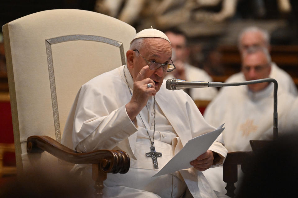 Pope Francis speaks into a microphone at St. Peter's Basilica in Vatican City. 