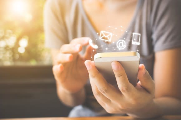 A woman uses communication apps on her phone.