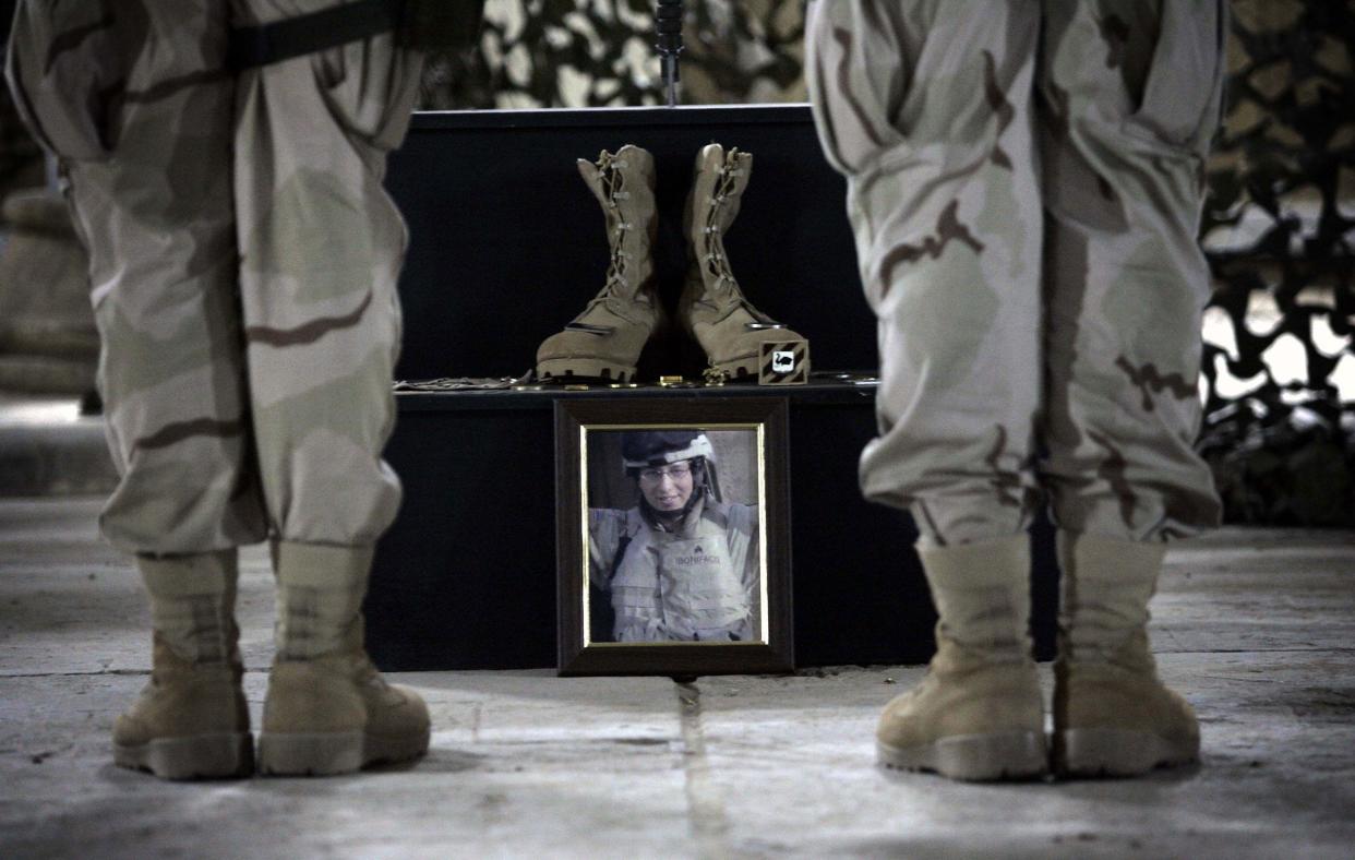 A photo of fallen U.S. soldier, Sgt. Jerry Lee Bonifacio Jr., from Bravo Company, 1-184 assigned to TF 4-64, 3rd Infantry Division, sits between the boots of soldiers standing at attention during a memorial service at US army base FOB Prosperity, in central Baghdad on Oct. 13, 2005.