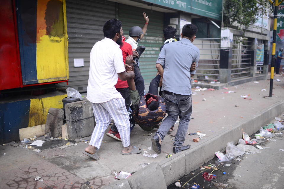 People carry a police officer injured in a protest in Dhaka, Bangladesh, Saturday, Oct. 28, 2023. Police in Bangladesh's capital fired tear gas to disperse supporters of the main opposition party who threw stones at security officials during a rally demanding the resignation of Prime Minister Sheikh Hasina and the transfer of power to a non-partisan caretaker government to oversee general elections next year. (AP Photo/Mahmud Hossain Opu)