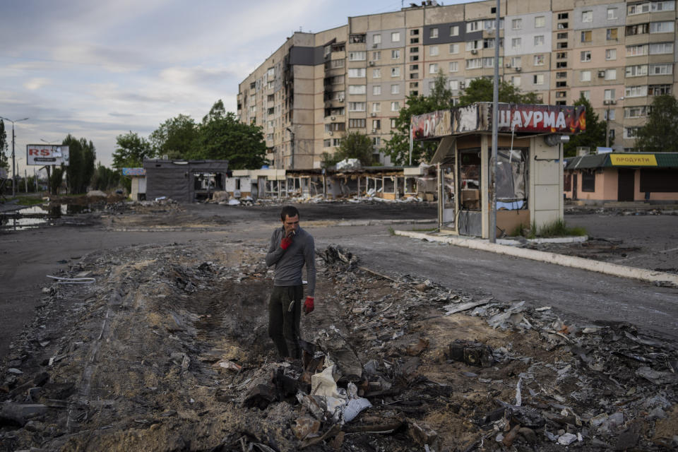 A man searches for metal scraps in a shelled neighbourhood in Kharkiv, eastern Ukraine, Thursday, May 19, 2022. (AP Photo/Bernat Armangue)