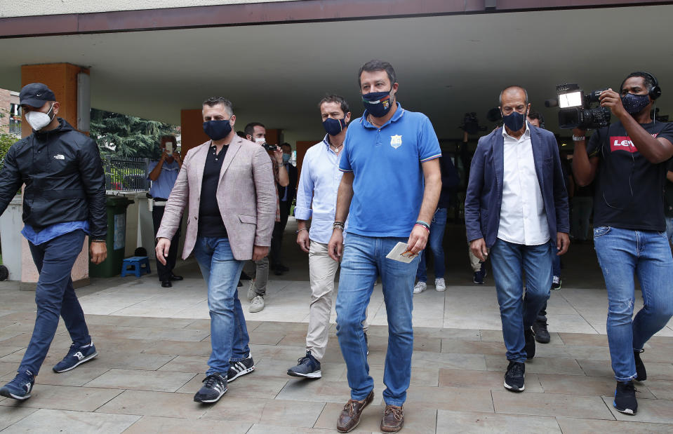 Right-wing opposition leader Matteo Salvini,center, leaves a polling station, in Milan, Italy, Monday, Sept. 21, 2020. On Sunday and Monday Italians are called to vote nationwide in a referendum to confirm a historical change to the country's constitution to drastically reduce the number of Members of Parliament from 945 to 600. Eighteen million of Italian citizens will also vote on Sunday and Monday to renew local governors in seven regions, along with mayors in approximately 1,000 cities. (AP Photo/Antonio Calanni)