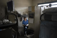 Joseph Sena, 27, reads a document in his cell at Valley State Prison in Chowchilla, Calif., Friday, Nov. 4, 2022. Sena spent years trying to make himself a better person after spending nearly half of his 27 years in prison for killing a man. He took courses in poetry and mental health and other topics at a central California prison, hoping to be seen as fit for parole and ready to live outside prison if the day he was free ever came. (AP Photo/Jae C. Hong)