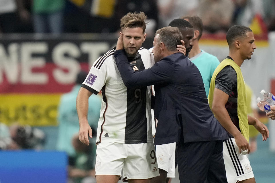 Germany's head coach Hansi Flick embraces Niclas Fuellkrug after he scored their side's first goal during the World Cup group E soccer match between Spain and Germany, at the Al Bayt Stadium in Al Khor , Qatar, Sunday, Nov. 27, 2022. (AP Photo/Matthias Schrader)