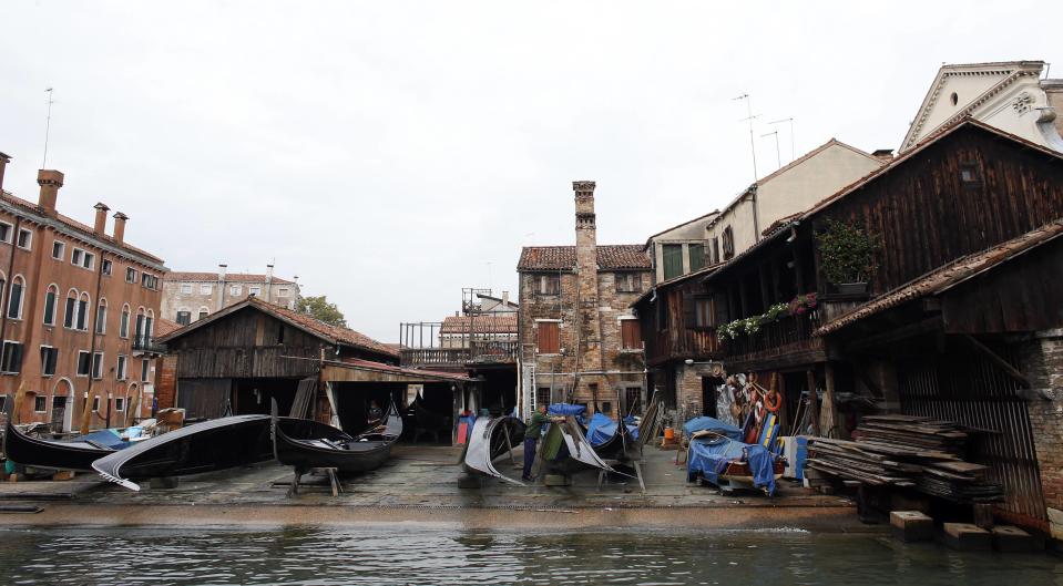 A worker cleans a gondola at the San Trovaso boatyard, also known as a