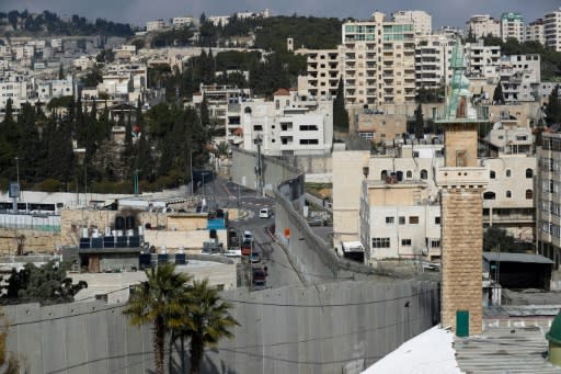 Israel's separation barrier dominates life in Abu Dis, on the right of the picture