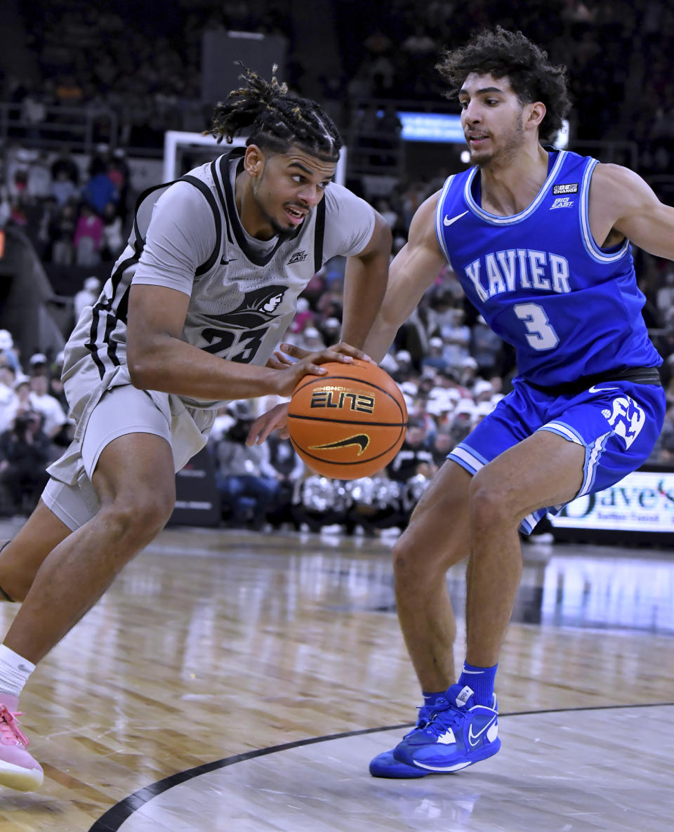 Providence forward Bryce Hopkins (23) drives around Xavier guard Colby Jones (3) during the second half of an NCAA college basketball game Wednesday, March 1, 2023, in Providence, R.I. (AP Photo/Mark Stockwell)