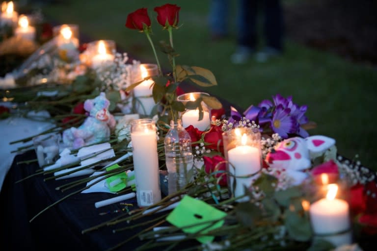 Candles, flowers and stuffed animals line a table during a vigil for victims of a shooting at Santa Fe High School in Texas, where a student opened fire on classmates, killing 10 people