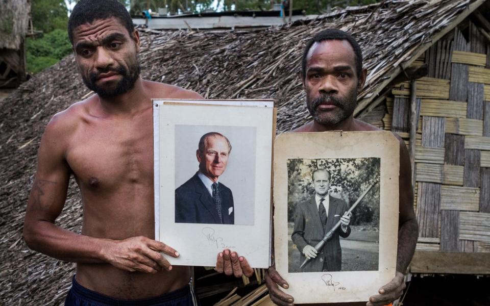 Men from the village of Yaohnanen hold portraits of the Duke, which he gave the village in 2012 - Roman Kalyakin/Corbis